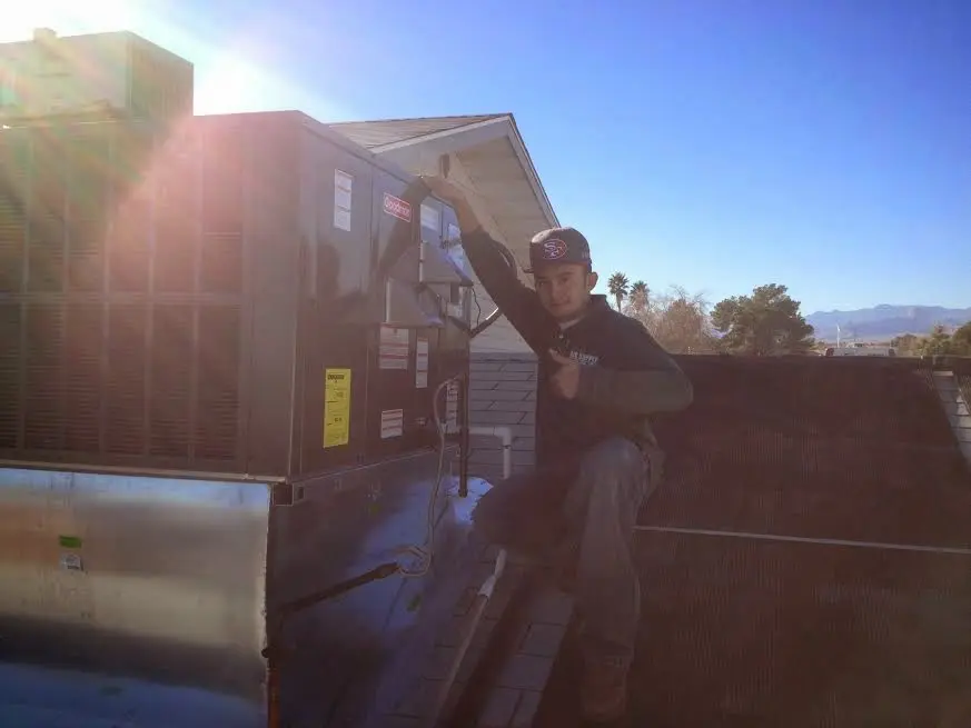 HVAC technician performing Heat Pump Repair on a rooftop unit in Middleton